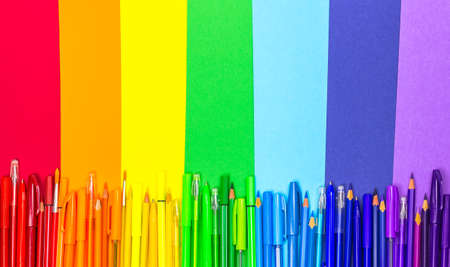 Back to school. School supplies are laid out in the form of a rainbow. Pens, pencils, markers of rainbow colors are on colored paper. The view from the top, place for textの写真素材
