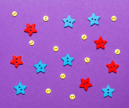 Buttons in the form of stars and circles lie on a purple background. Decorative night for a...
