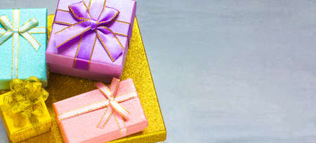Purple, pink, blue and gold gift box with grey background. Holiday greeting card. Christmas, new...