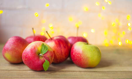 Festive autumn decor of apples on a white brick background with bokeh. The concept of Thanksgiving...