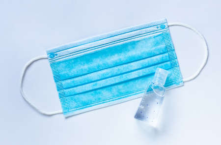 Medical mask and alcohol gel to protect against infection during a virus outbreak. Top view on a...