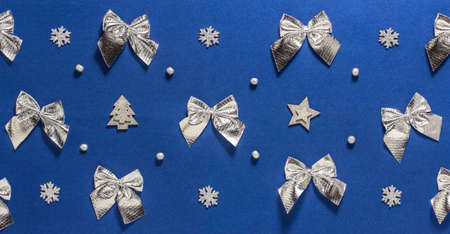 Background with Christmas silver bows, snowflakes and beads on a dark blue background. New year,...