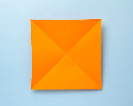 Step-by-step photo instruction on how to make a bookmark for a book in the form of an orange tiger from paper with your own hands. The symbol of the new year 2022. Step 1. Fold the sheet diagonallyの写真素材