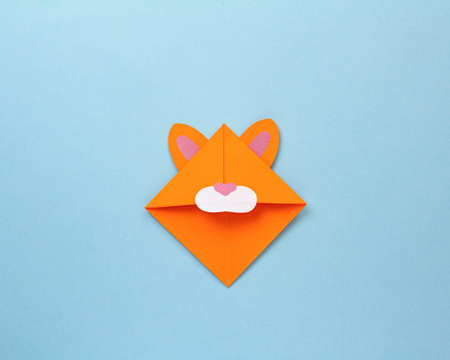 Step-by-step photo instruction on how to make a bookmark for a book in the form of an orange tiger out of paper with your own hands. The symbol of the new year 2022. Step 7. Glue the ears and muzzleの写真素材