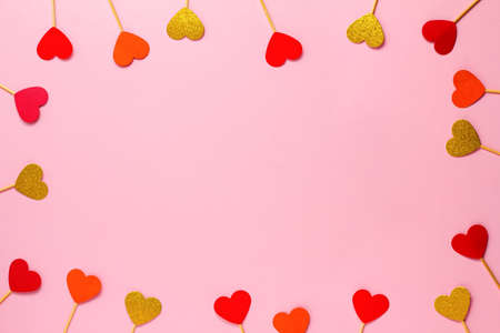 Valentines day background of red and gold hearts on a pink background. Wedding, birthday. Flatlay, copy spaceの写真素材
