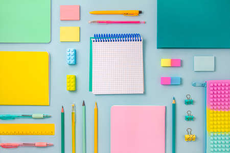 The concept of back to school. Pastel-colored stationery and an inscription pad are arranged in...