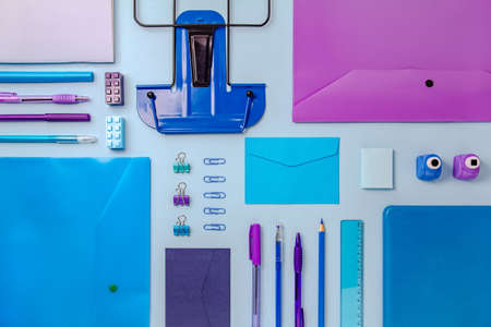 The concept of back to school. School supplies and stationery in blue and purple are arranged on a blue background in order.の写真素材