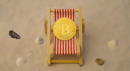 Bitcoin coin in deck chair on the beach