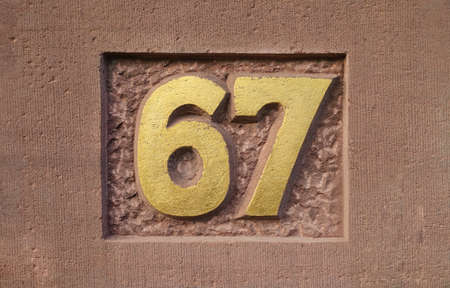 House number 67 with golden surfaceの写真素材
