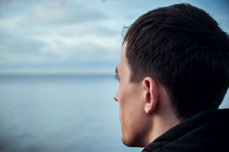 The guy looks at the ocean. Appeasement. Fotoの写真素材