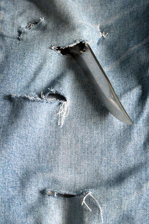 Improving blue jeans with sharp knifeの写真素材