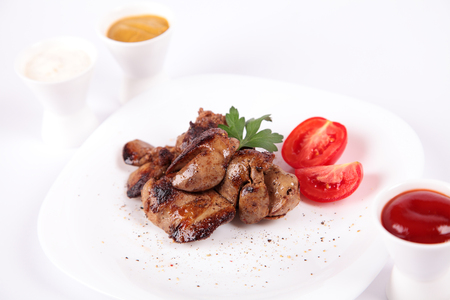 fried chicken livers with tomato and parsley close upの写真素材