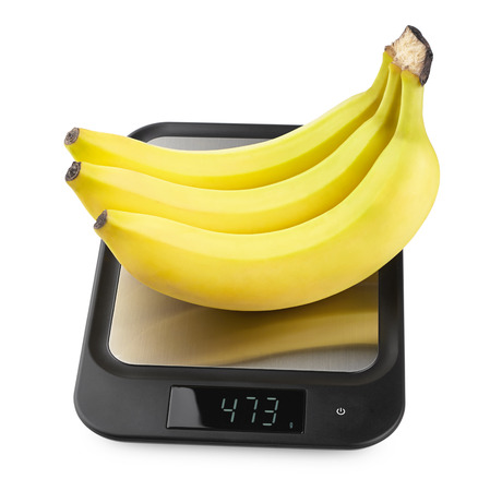 fresh appetizing bananas. fruit on kitchen scales isolated on whiteの写真素材