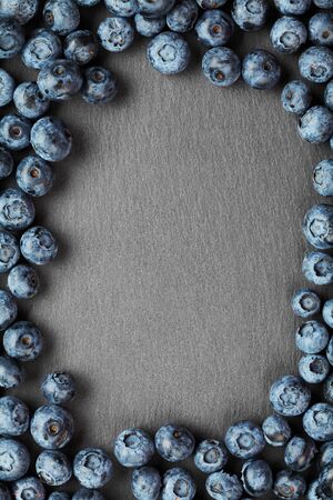 framing from berries wild berries top view, high sharpness blueberries on a dark stone backgroundの写真素材