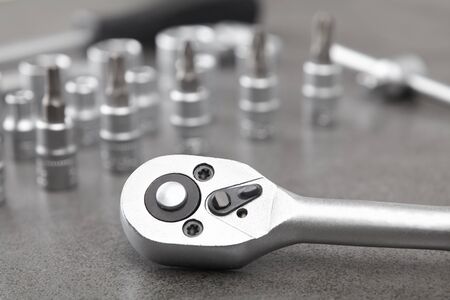 ratchet set with heads, different socket wrenches close-up on a dark stone background