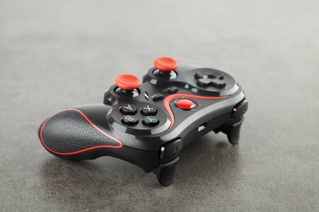 new wireless game controller close-up, black gamepad on a dark stone background