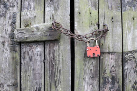 Padlock with chain on a old wooden doorの写真素材
