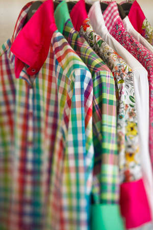 colorful blouses hanging on a clothes rodの写真素材