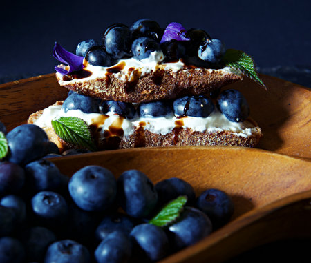 Fresh blueberries with whipped cream and mint on a wooden plate.の写真素材