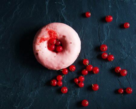 Red currant donut on black marble background. Top view.の写真素材