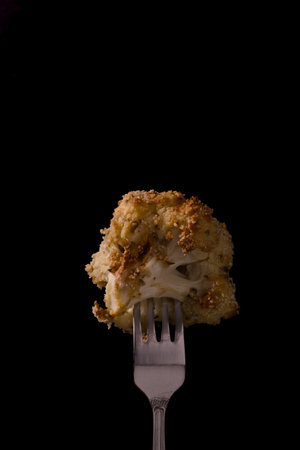 cauliflower on a fork on a black backgroundの写真素材