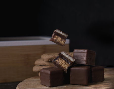 Chocolate candy on a wooden board on a black background. Selective focus.の写真素材