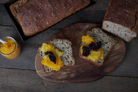 Slices of rye bread with apricot jam on wooden background