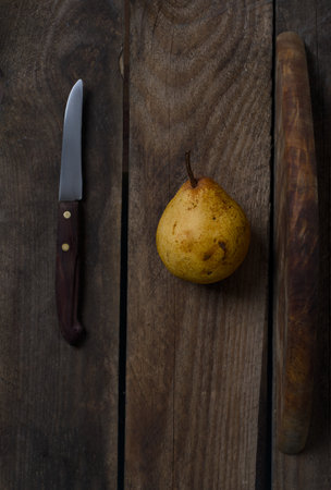 pear and knife on a wooden background. tinting. selective focusの写真素材