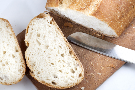 Slice of white bread on a wooden board, knifeの写真素材