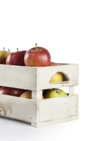 Fresh apples in a wooden crate on white backgroundの写真素材