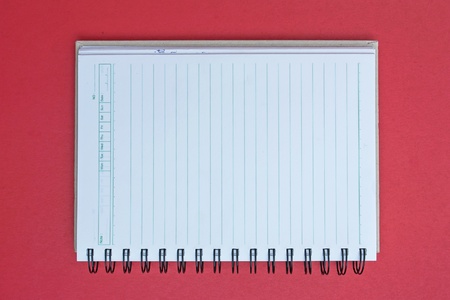 spiral notebook on red background.