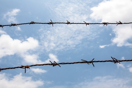 Barb wire against blue sky