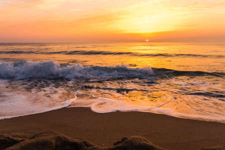 Golden sunrise sunset over the sea ocean wavesの写真素材