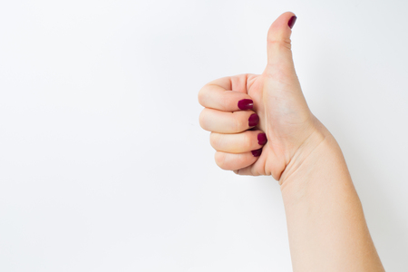 thumb up hand sign. woman hand showing thumb up, like, good, approval, acceptance, okay, ok, positive hand gestureの写真素材