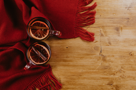 Decorated composition of mugs with mulled wine in knitted scarf, close upの写真素材