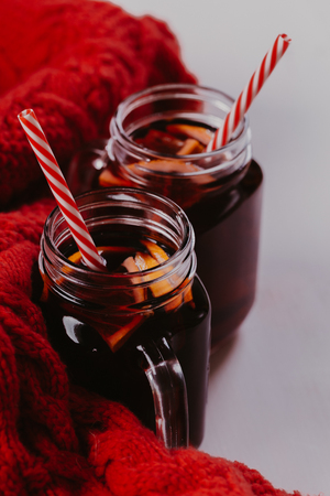 Decorated composition of mugs with mulled wine in knitted scarf, close up.の写真素材