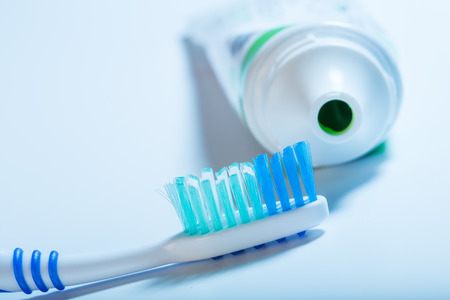toothbrush and toothpaste tube on blue background