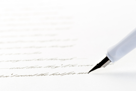 white fountain pen writing a letter