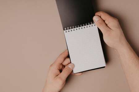 hand holding notebook on gray backgroundの写真素材
