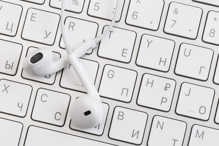white earphones on white keyboard