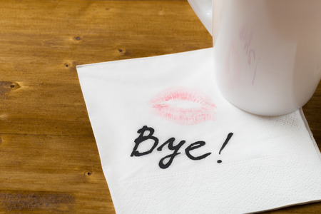 Napkin with a kiss and coffee cup on wooden backgroundの写真素材