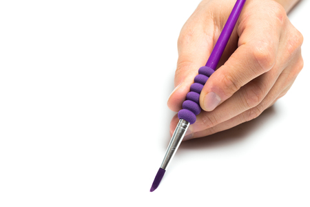Men's hand holding color brush on isolated backgroung, close upの写真素材
