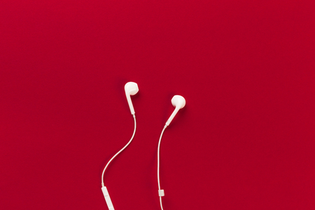 White earphones on red background