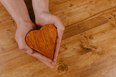 wooden oak heart in hands , valentines dayの写真素材