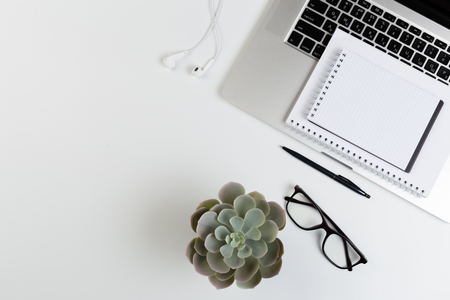 Top View of trendy White Office Desk with keyboard, white earphones and office suppliesの写真素材