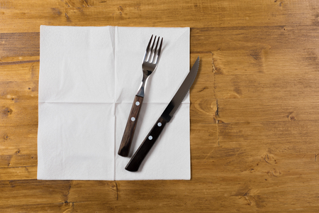 Cutlery and paper napkin on wooden backgroundの写真素材