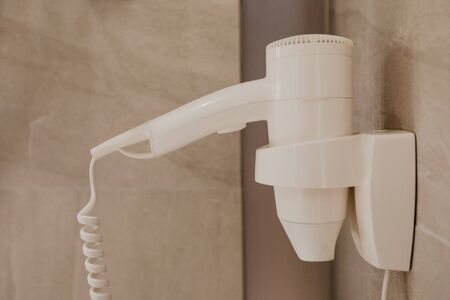 A modern electric hairdryer on the hotel wall - Imageの写真素材