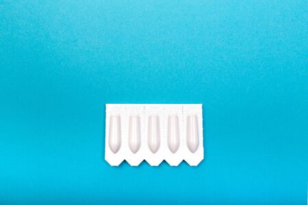 plastic packs of suppositories on blue  background - Image