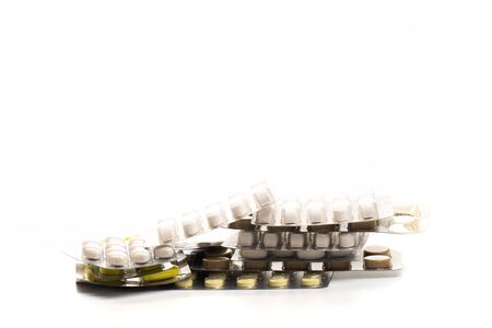 Some tablets blister packs with various pills and capsules stacked and on white background - Imageの写真素材