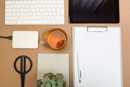 office desk table with tablet  clipboard keyboard notebook tea cup disc and scissors. Mock up template . Top view.- Imageの写真素材